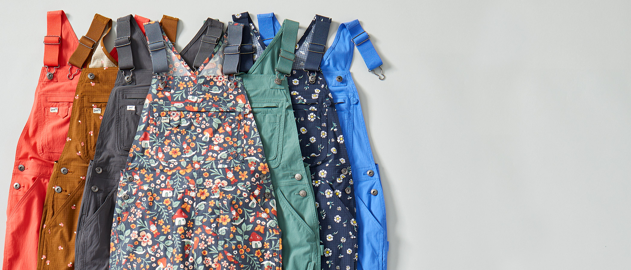 A collection of Heirloom Gardening overalls in a variety of colors and patterns
