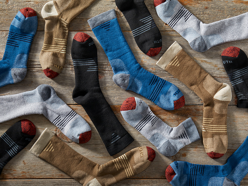 various colors of seven-year socks laying on a wood background